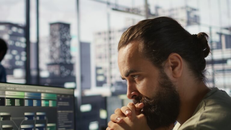 Pensive employee using computer to analyze datasets, focused on comparing datasets and checking accounting figures. Close up of man concentrating on solving tasks for team project, camera B